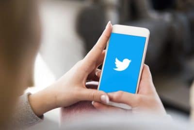 cell phone displaying white bird Twitter logo