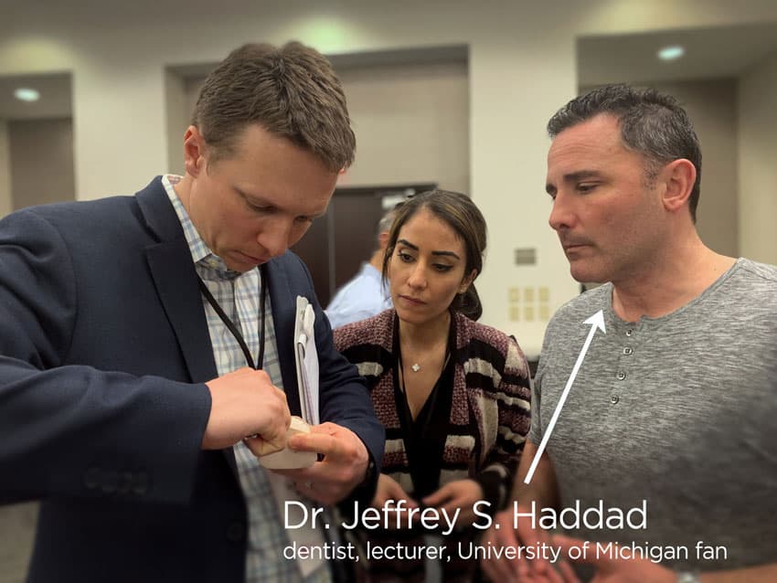 dentist, lecturer Dr. Jeffery Haddad discusses views an oral appliance therapy device with other colleagues. 